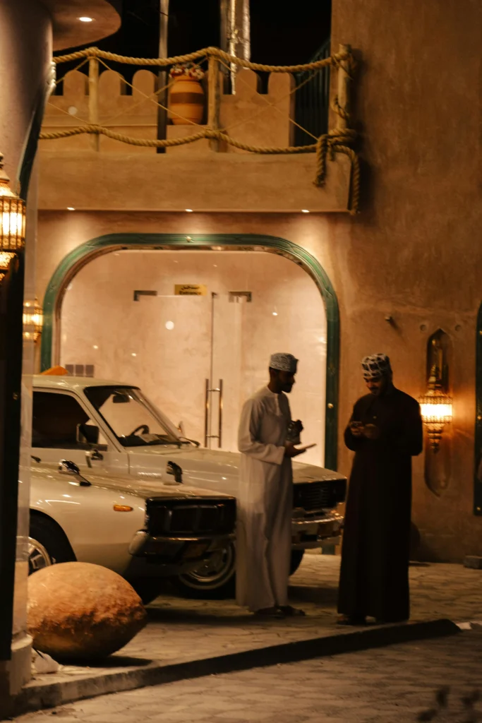 رجلان بجوار سيارة قديمة